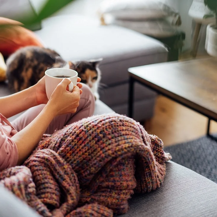 Woman sitting on the couch drinking a coffee