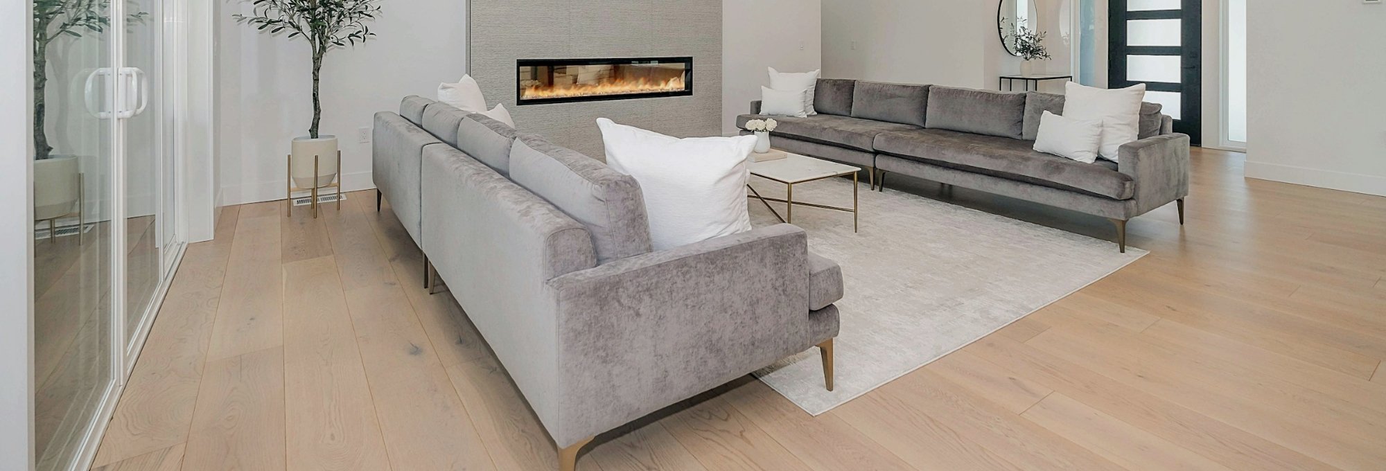 Modern and stylish living room with grey sofas and fireplace by local flooring experts in Philadelphia, PA & Cherry Hill, NJ